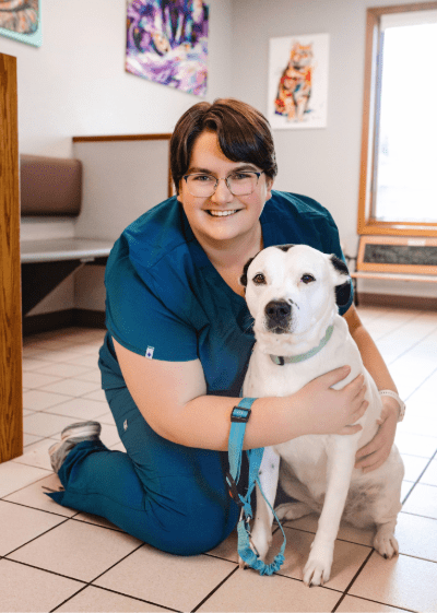 Mackenzie Mackenzie, CSR - female with short brown hair and glasses posing with white dog